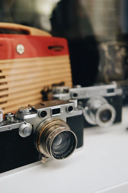 Close-up of a vintage camera and microphone on a dark wood table with gold accents.