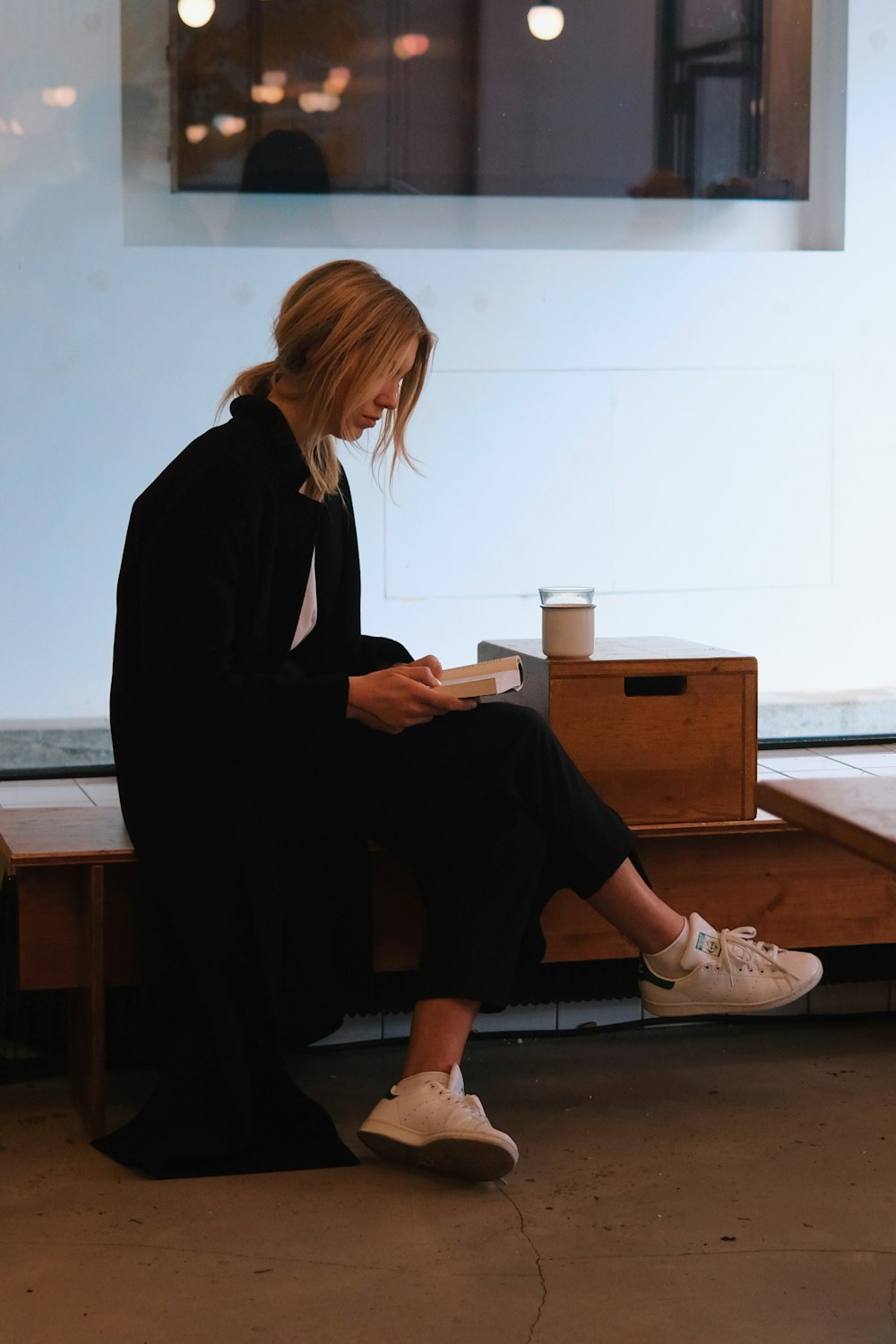 a woman sitting on a bench reading a book