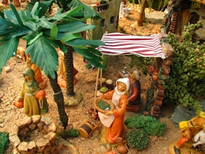 Miniature 1/64 scale diorama of a bustling market scene with tiny figures and colorful stalls.