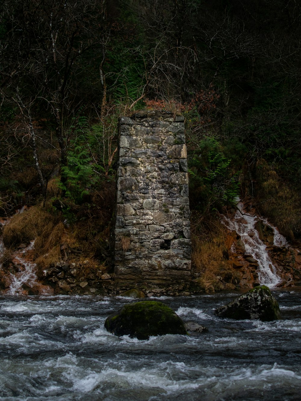 a stone tower in the middle of a river