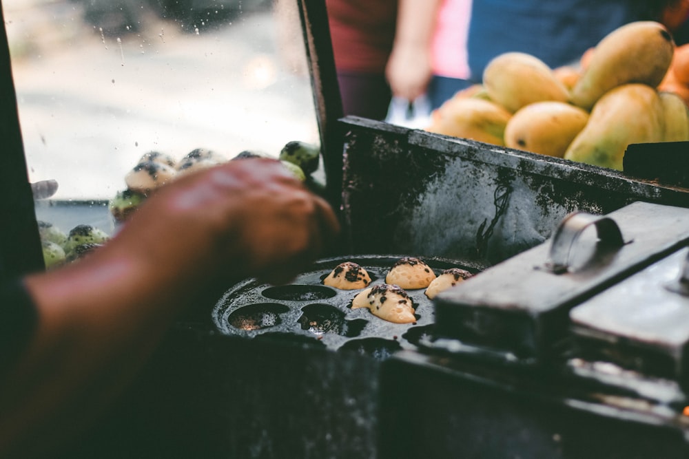 Un primer plano de una persona cocinando comida en una parrilla