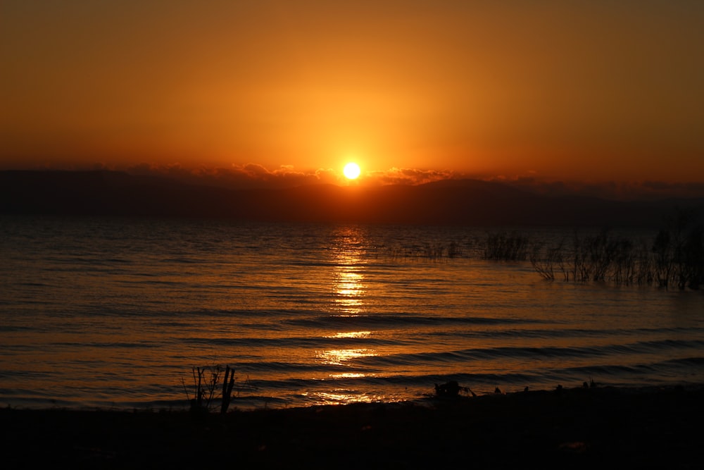 the sun is setting over a body of water