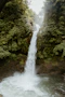 a large waterfall in the middle of a forest