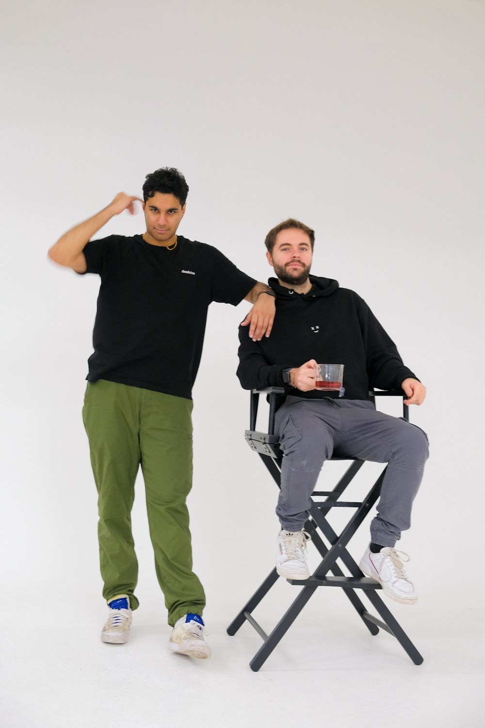 a man sitting in a chair next to another man