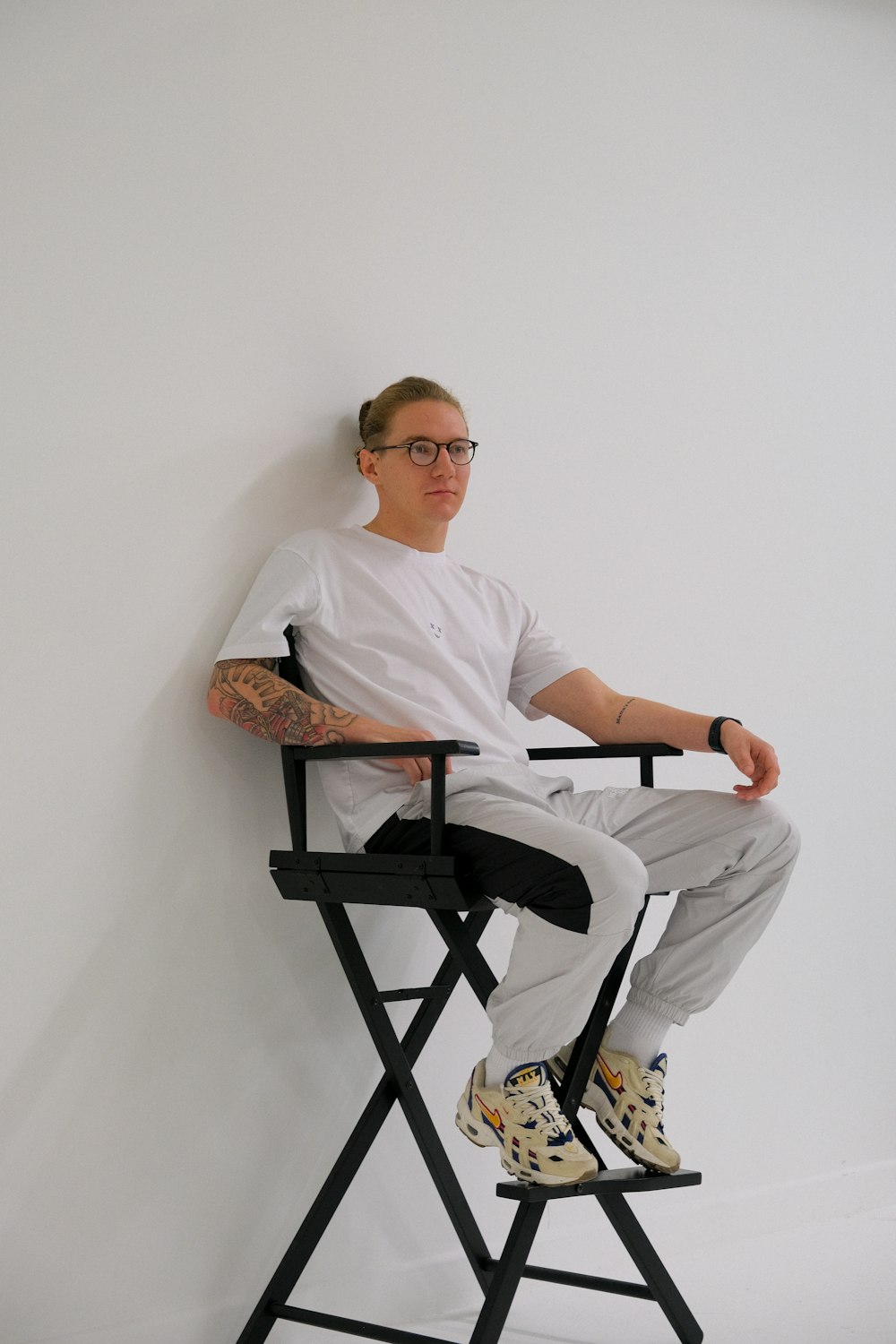 a man sitting in a chair with a tattoo on his arm