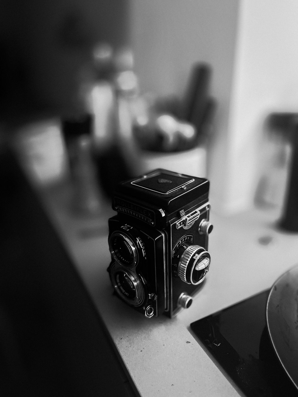 a black and white photo of a camera on a counter