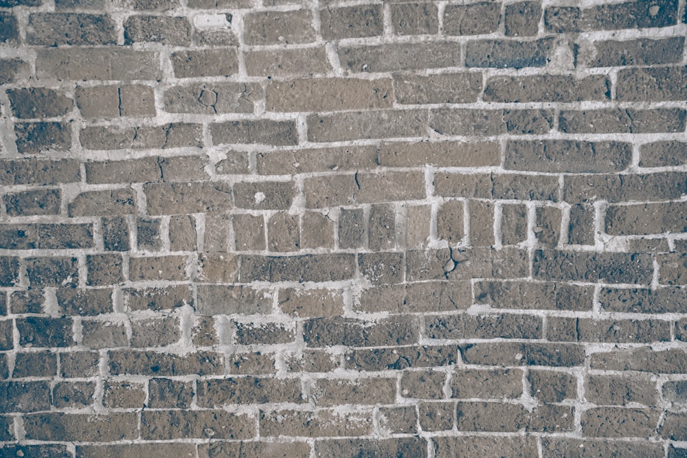 a red fire hydrant sitting on the side of a brick wall