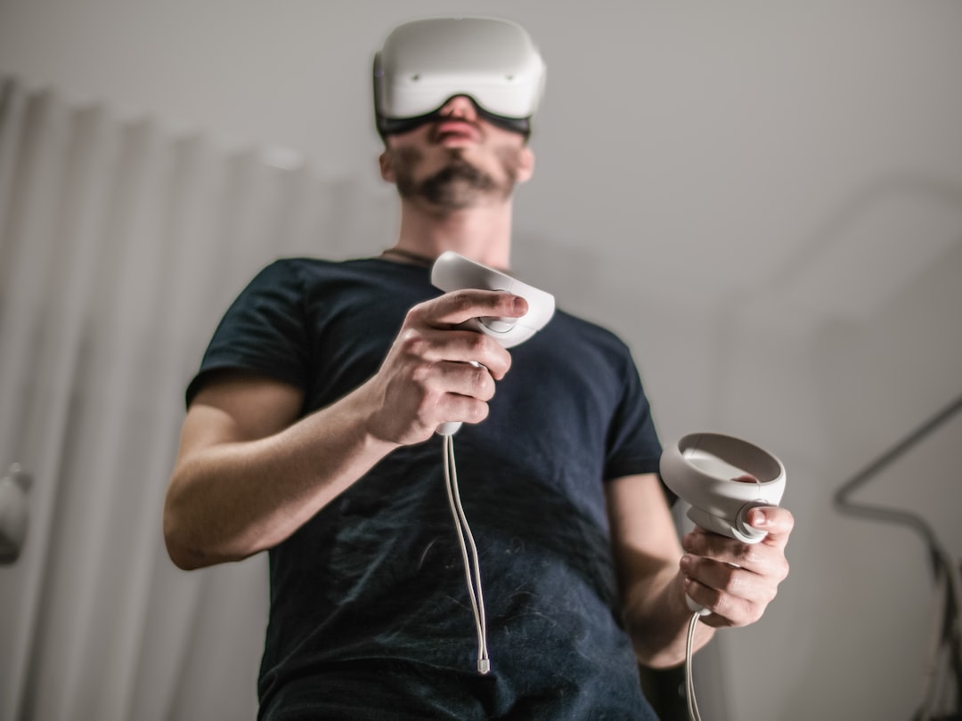 a man wearing a virtual reality headset holding a wii controller,