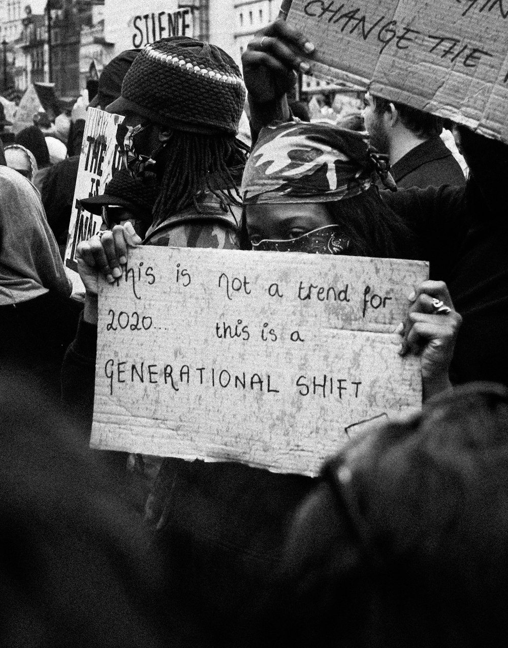 a black and white photo of people holding signs