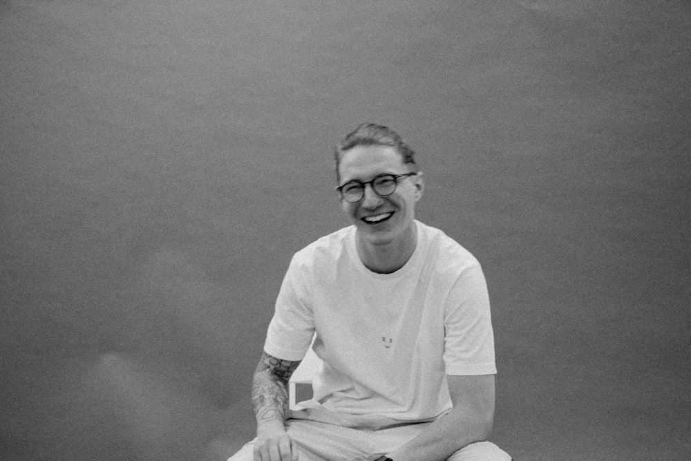 a black and white photo of a man sitting on a tennis court