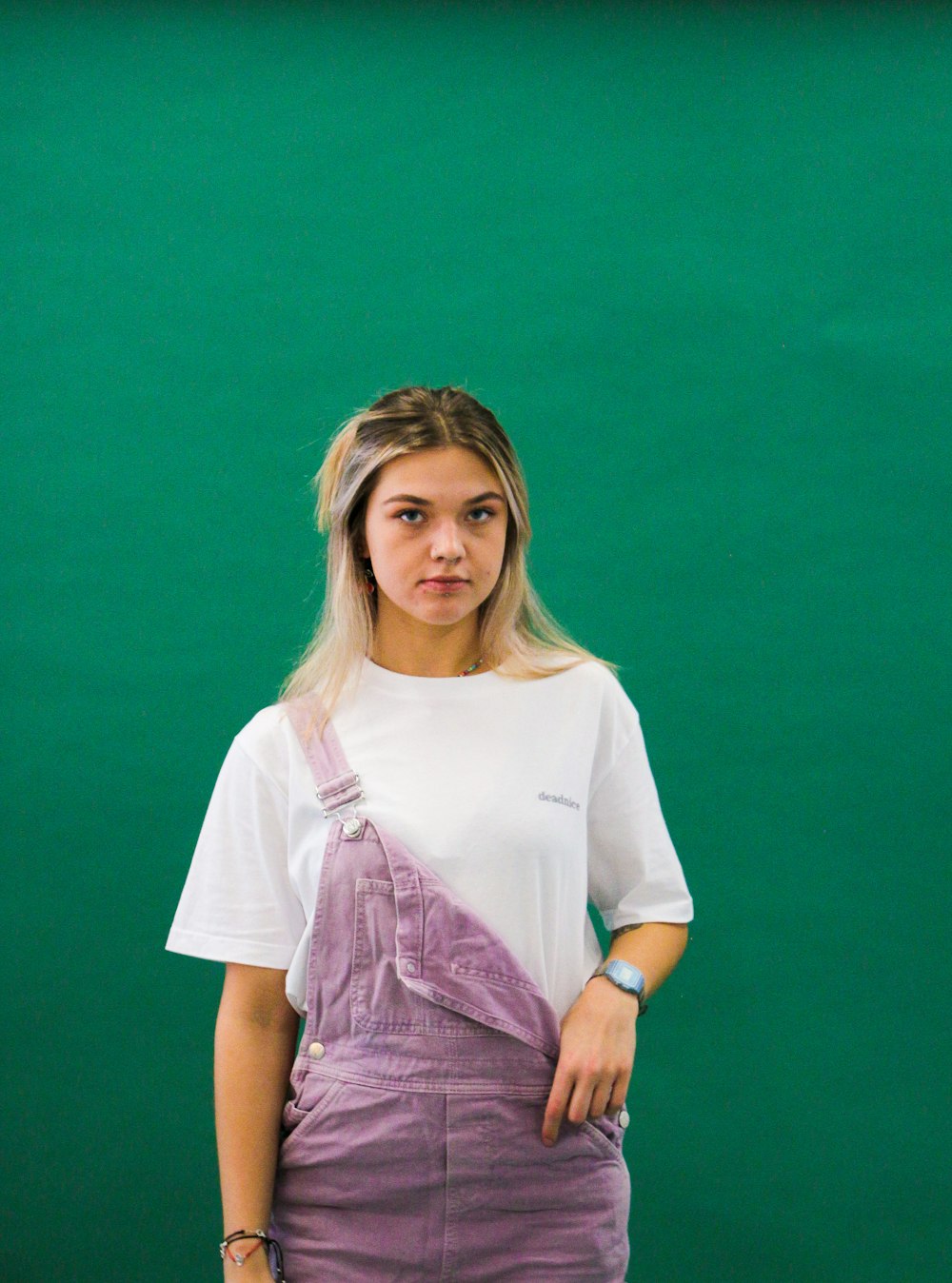 a woman standing in front of a green wall