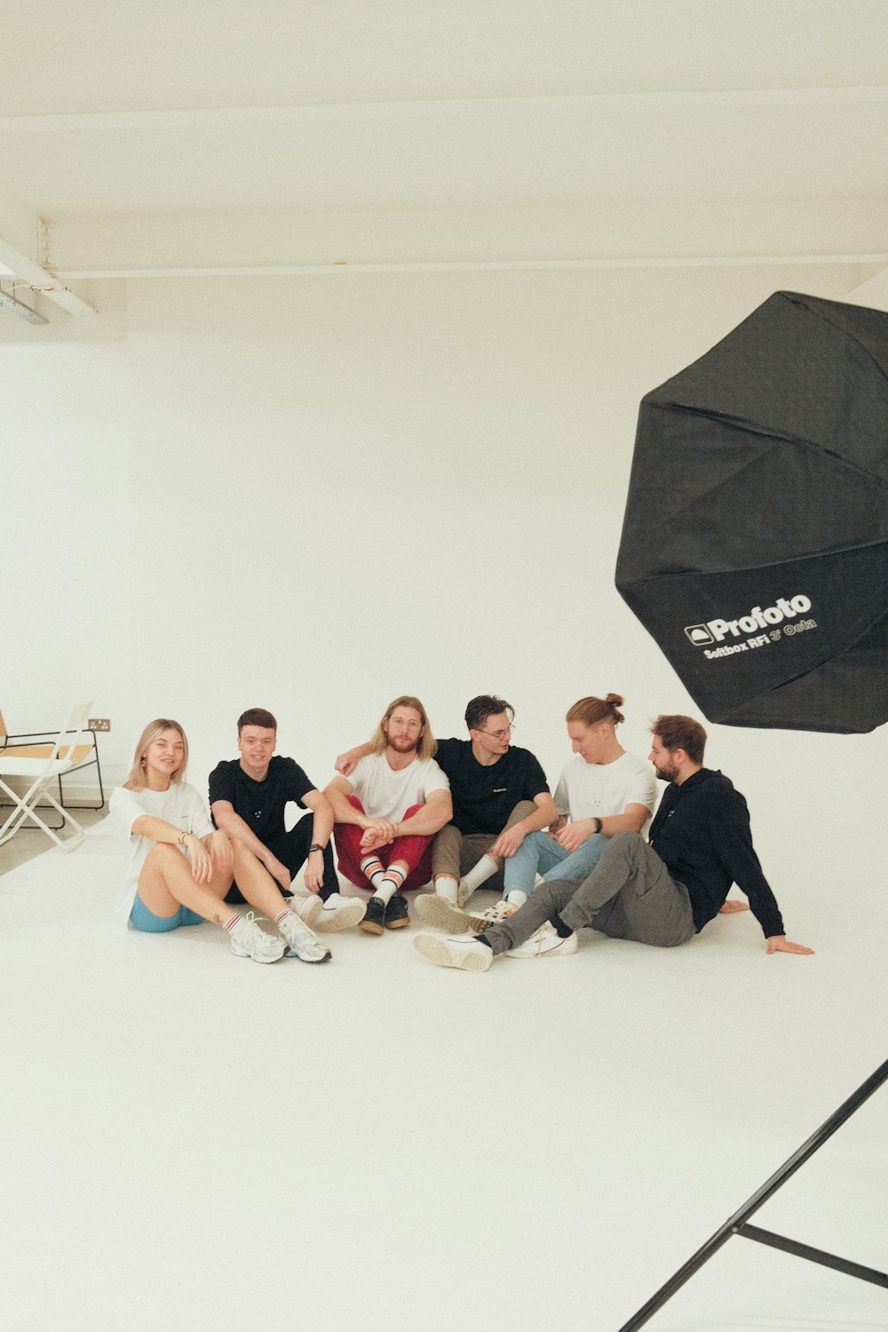 a group of people sitting in a room with a black umbrella
