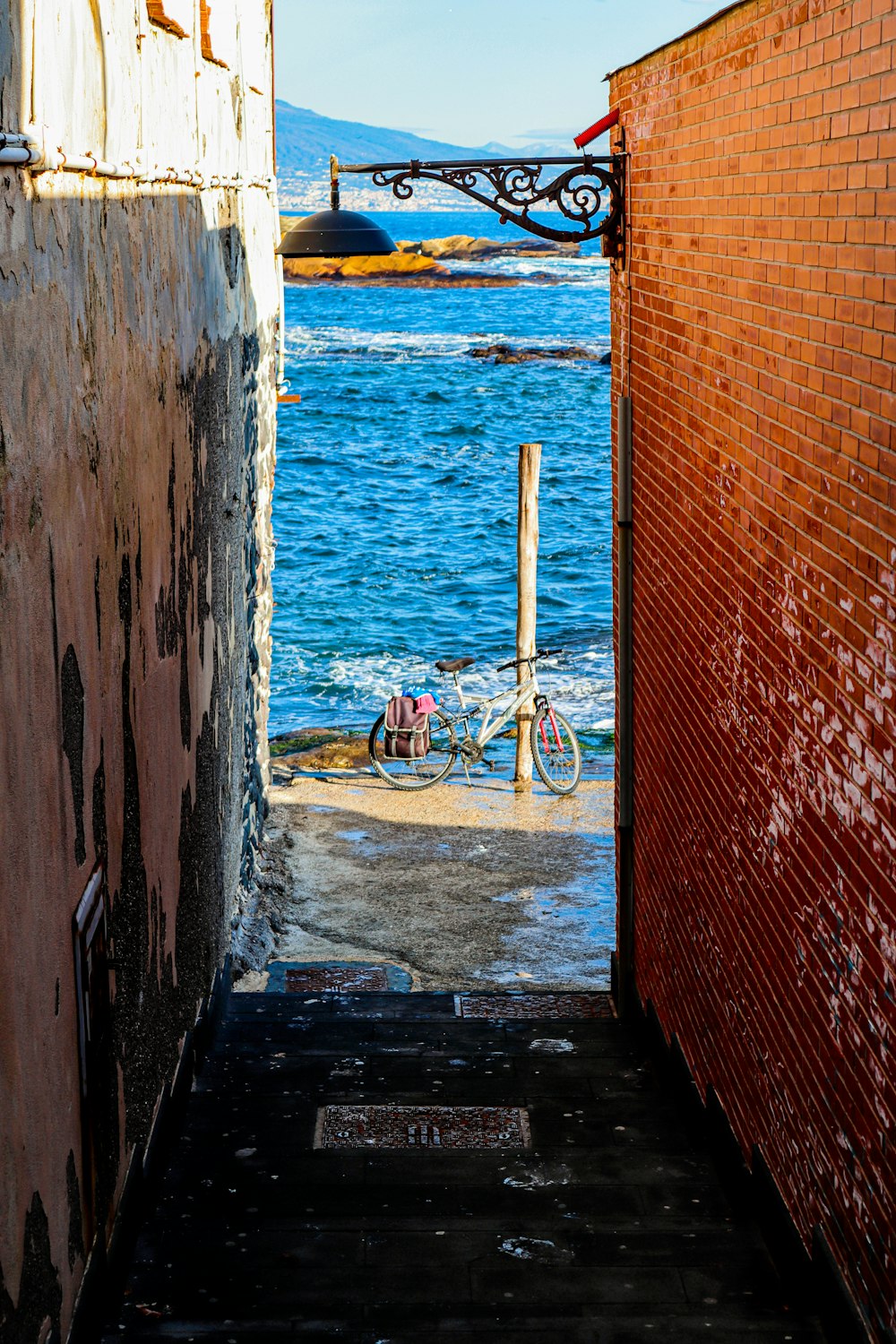 an alley way with a bicycle parked on the side of it