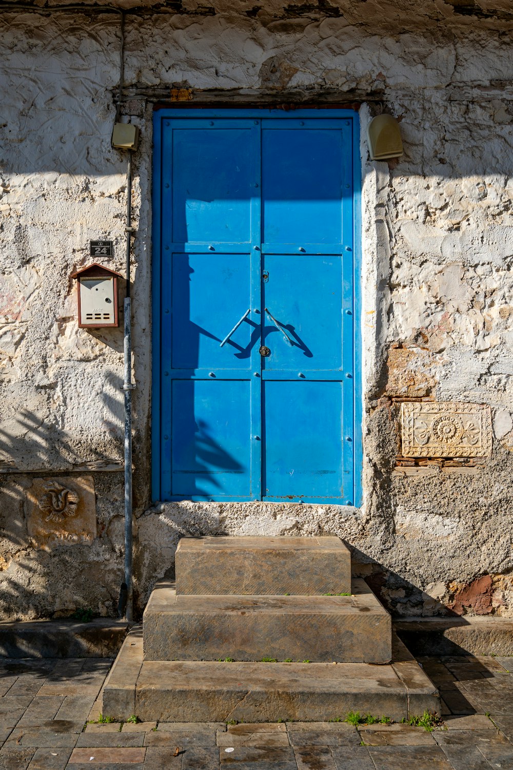 Una puerta azul y escalones frente a un edificio de piedra