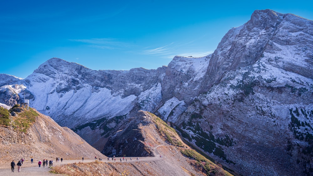 a group of people walking up a mountain side