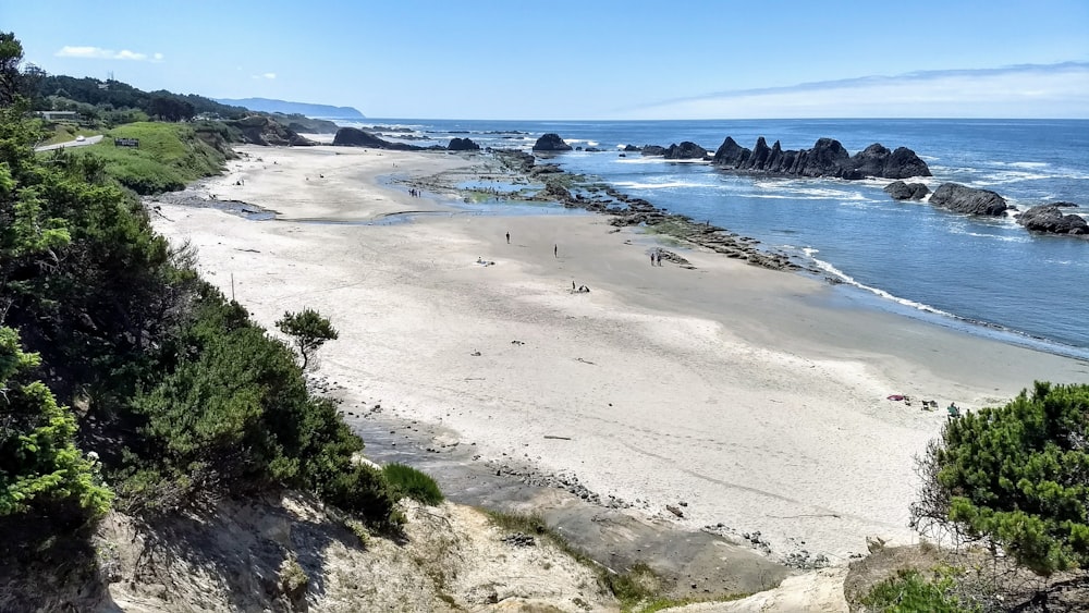 a sandy beach next to a body of water