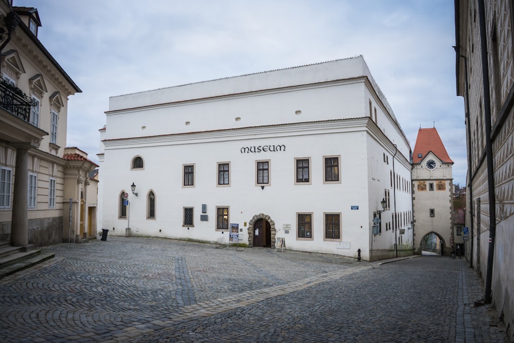 a white building sitting on the side of a cobblestone street