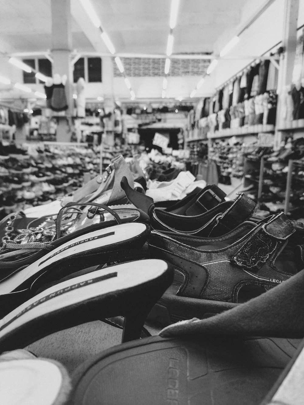 a black and white photo of shoes in a store