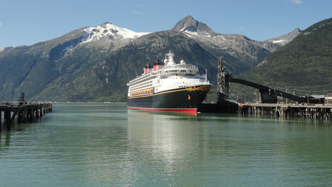 a large cruise ship docked at a pier, Disney Wonder cruise liner arriving in Skagway (Alaska)