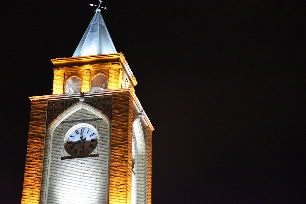 a large clock tower lit up at night