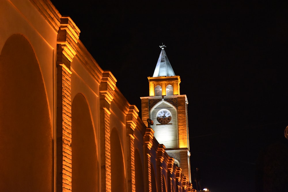 Una alta torre del reloj que se eleva sobre una ciudad por la noche