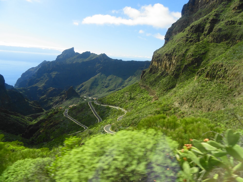 a scenic view of a winding road in the mountains