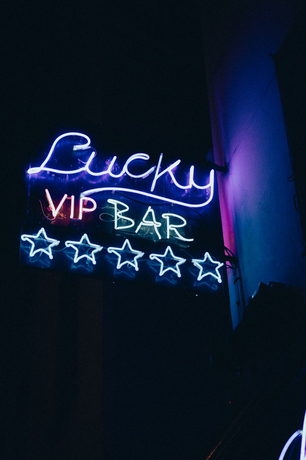 Un'insegna al neon che dice Lucky VIP Bar