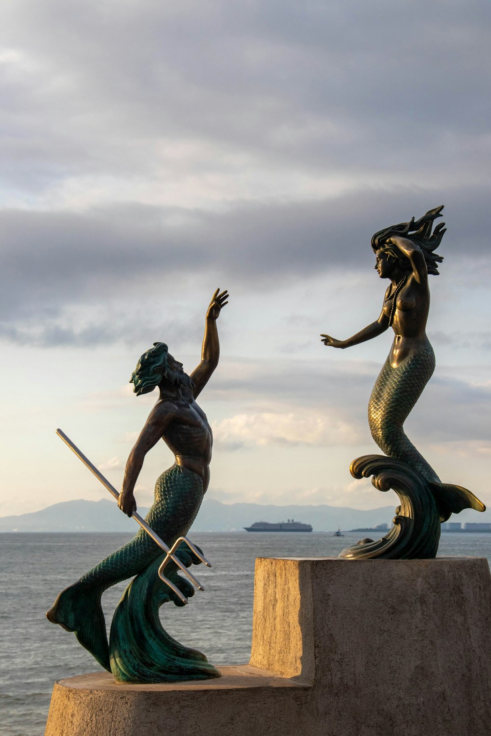 eine Statue einer Meerjungfrau und einer Meerjungfrau, die ein Schwert hält