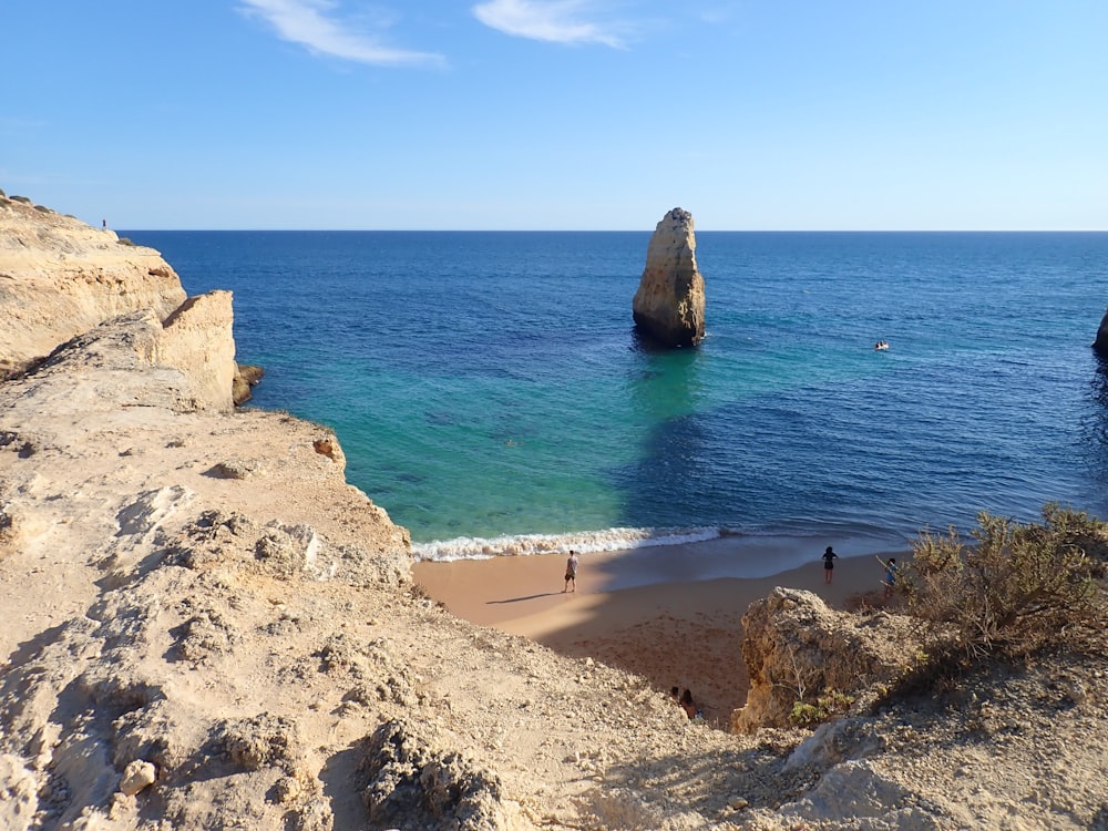 a person standing on a beach next to the ocean