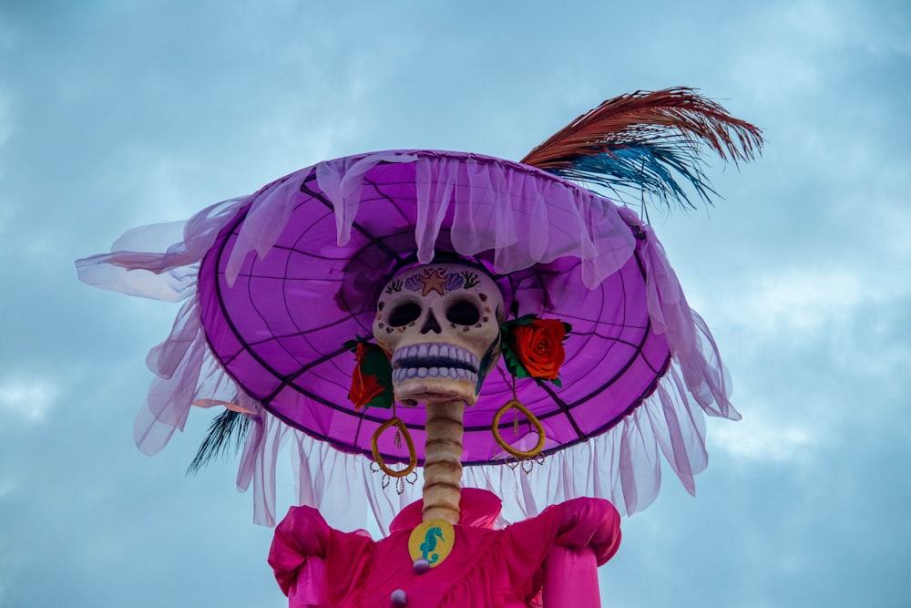 um esqueleto usando um chapéu roxo com penas