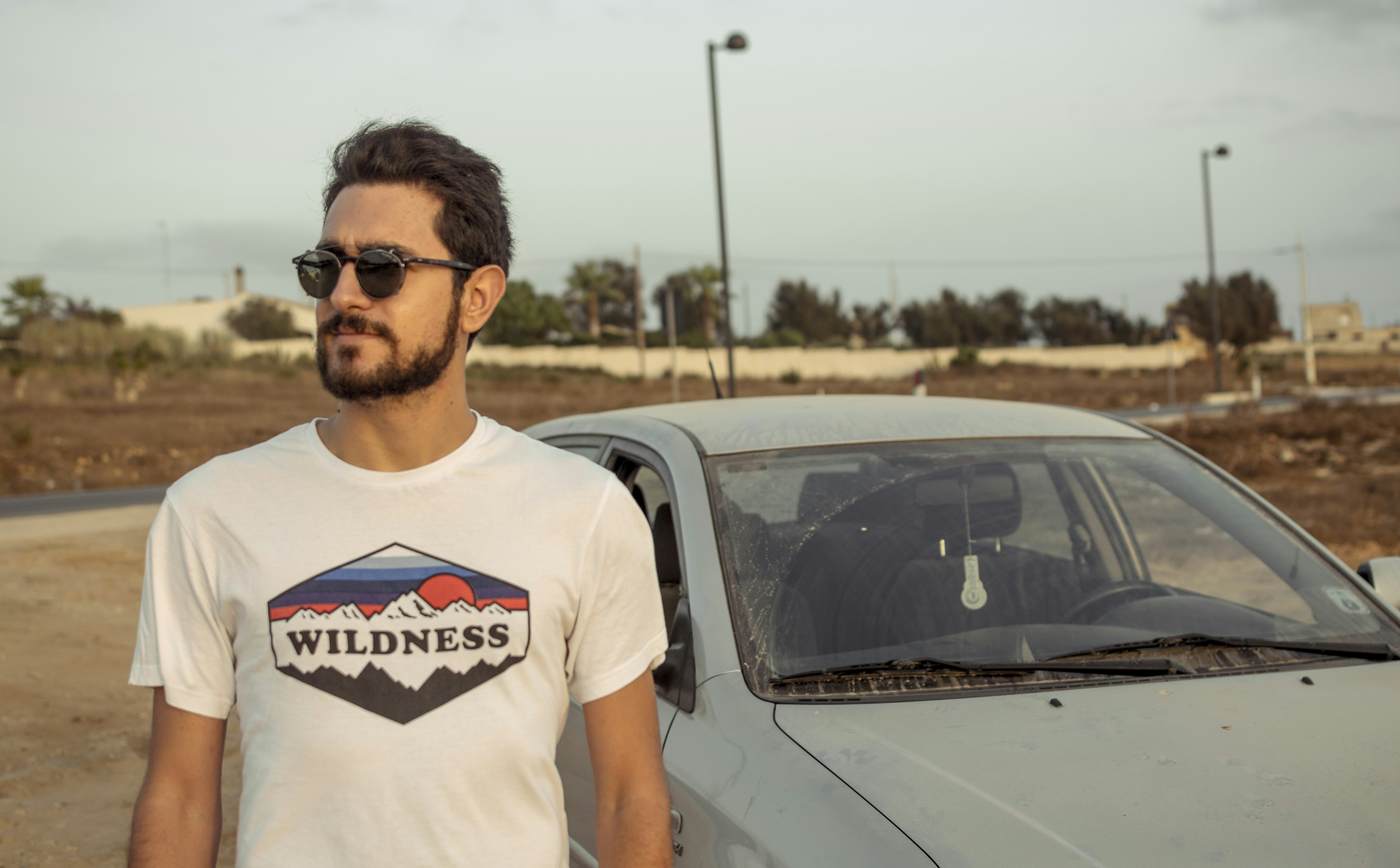 a man standing next to a parked car