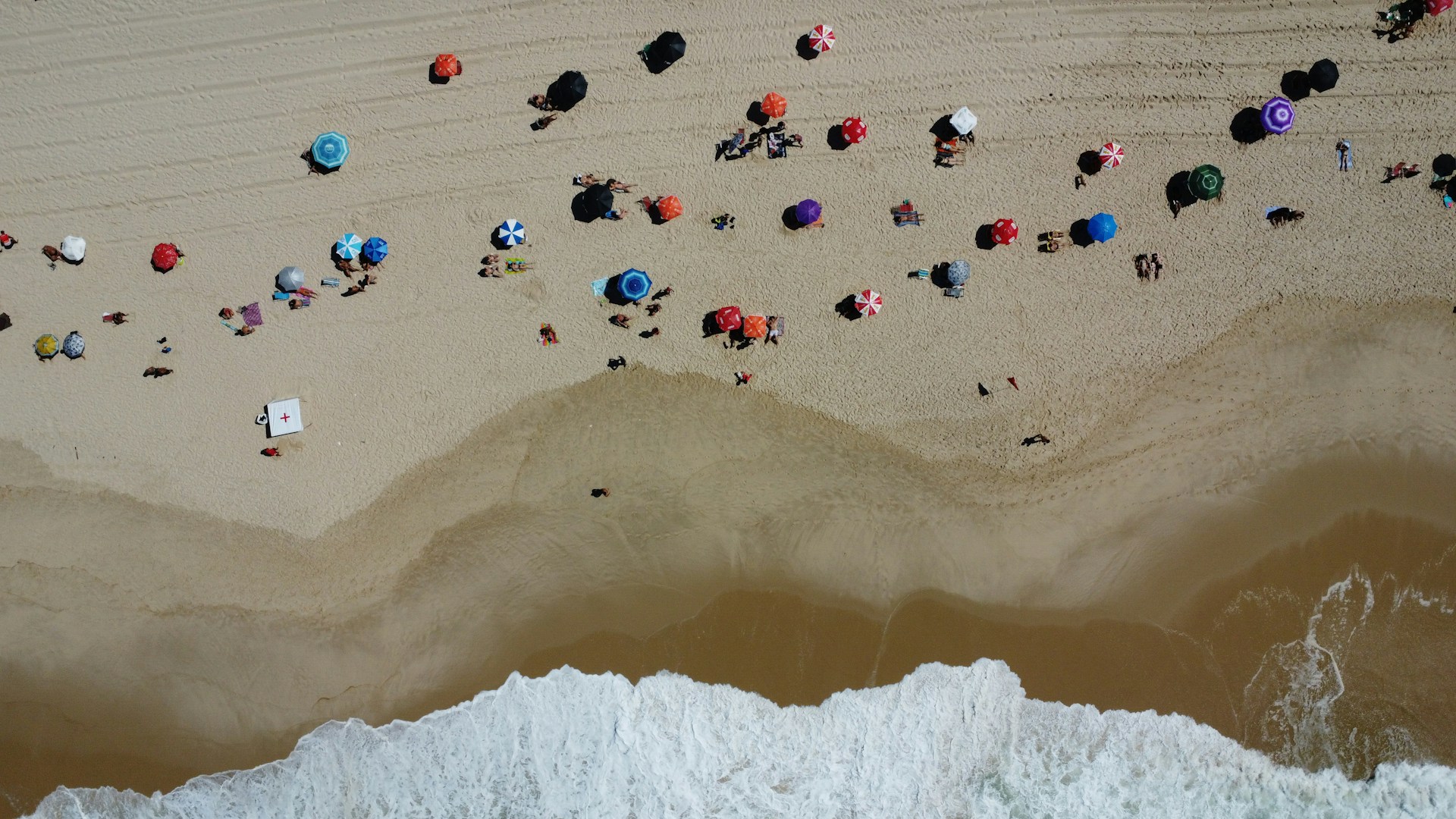 a group of people laying on top of a sandy beach
