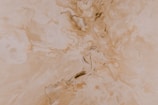 Cream texture swirled gently on a warm taupe stone surface.