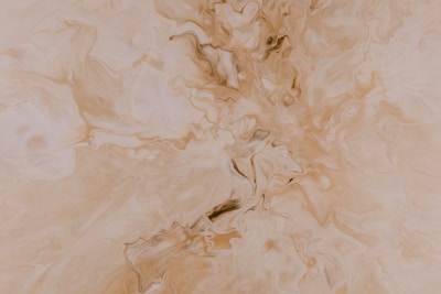Cream texture swirled gently on a warm taupe stone surface.