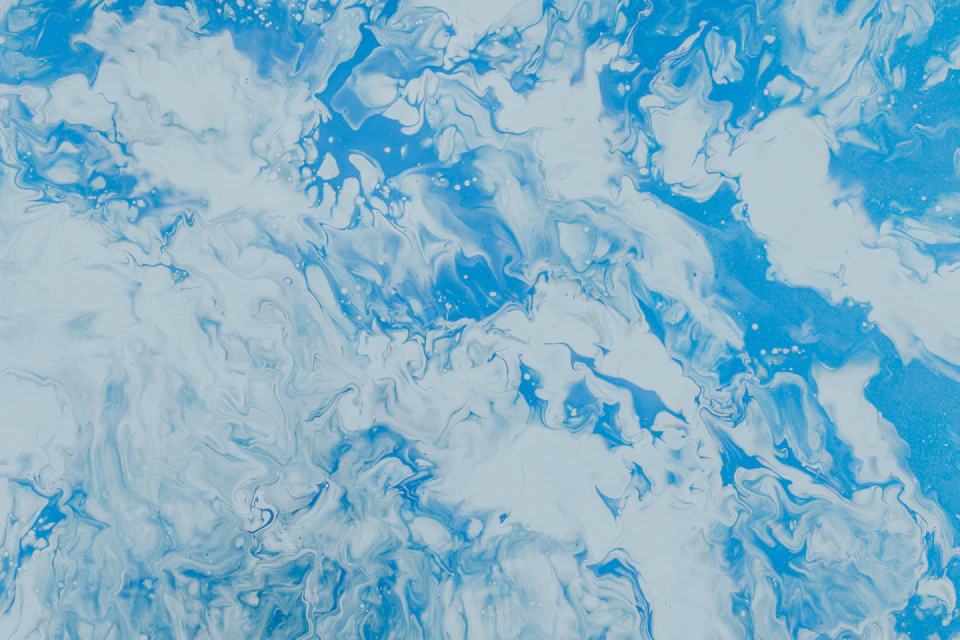 Close-up view of abstract painting featuring dominant blue and white shades with visible brushstrokes