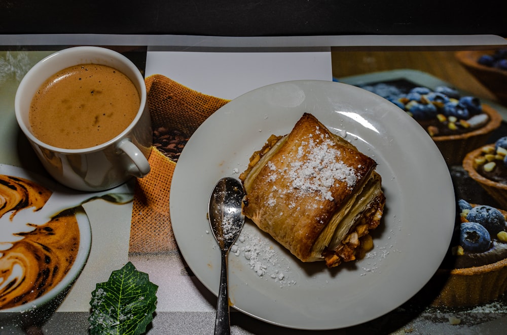 um prato branco coberto com comida ao lado de uma xícara de café