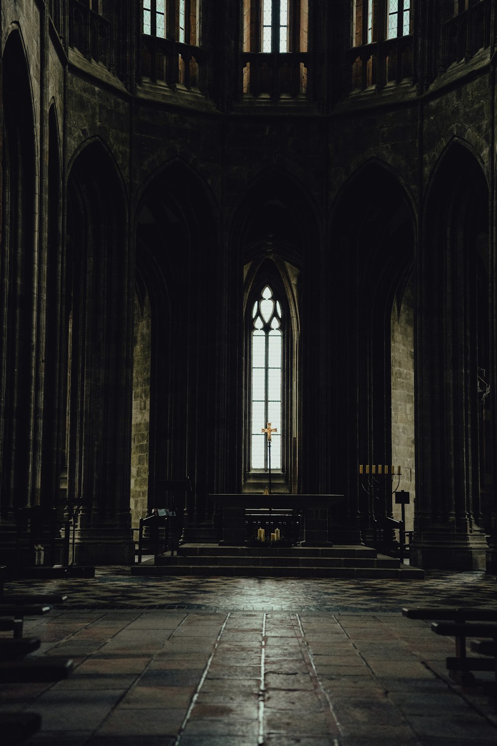 an empty church with a stone floor and a large window