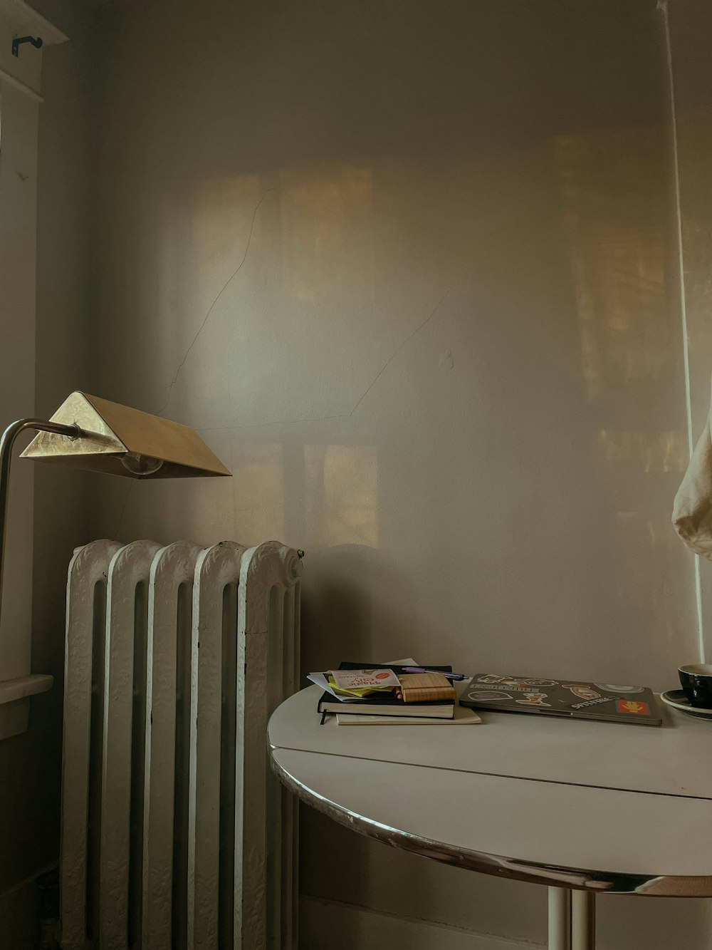 uma sala com um radiador e uma mesa com uma lâmpada sobre ele