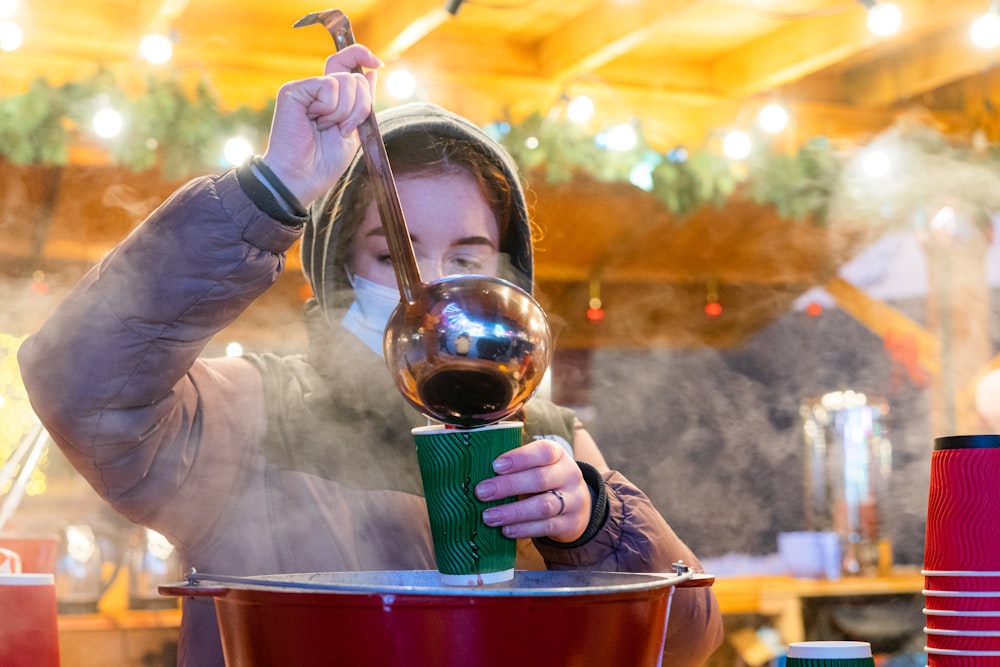 a woman is pouring a cup of coffee