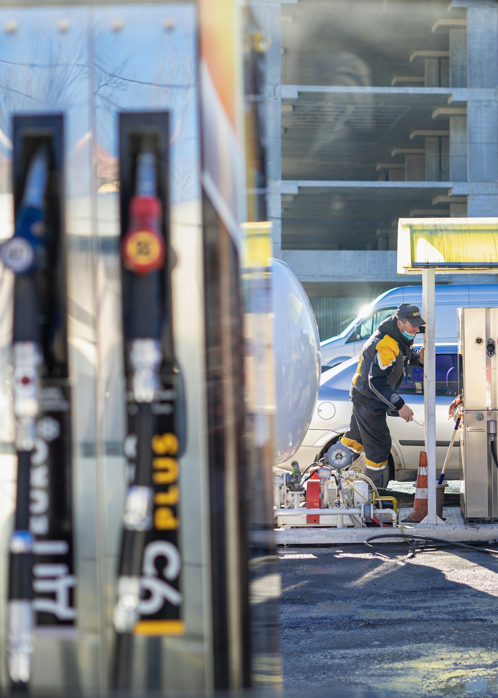 a man working on a car at a gas station