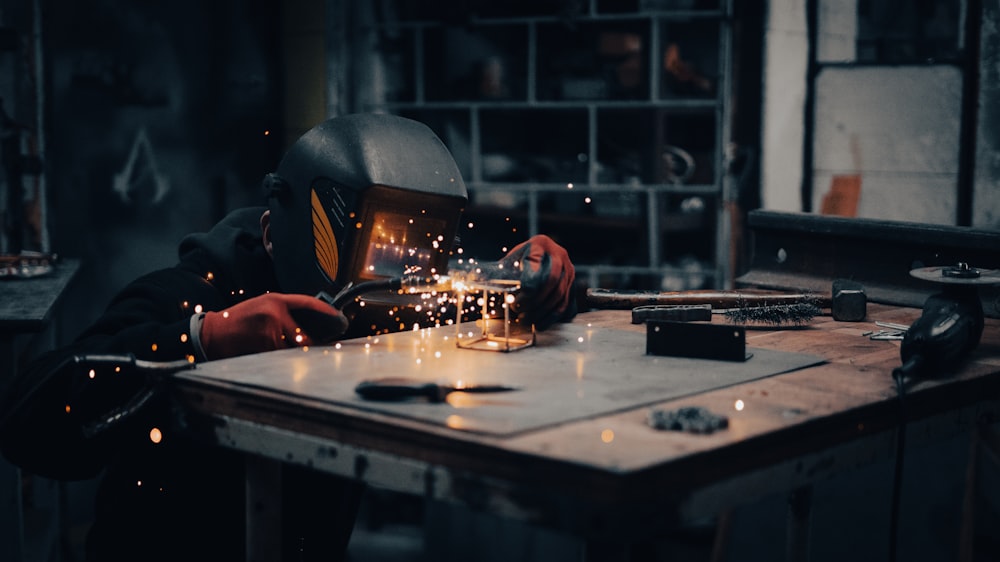um soldador trabalhando em um pedaço de metal