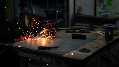 a man in a welding mask working on a piece of metal