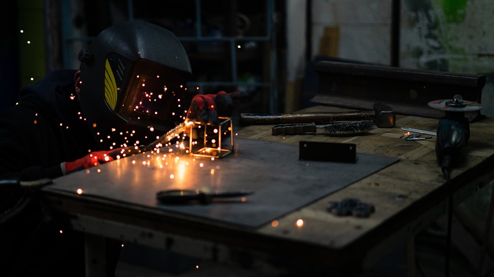 a man in a welding mask working on a piece of metal