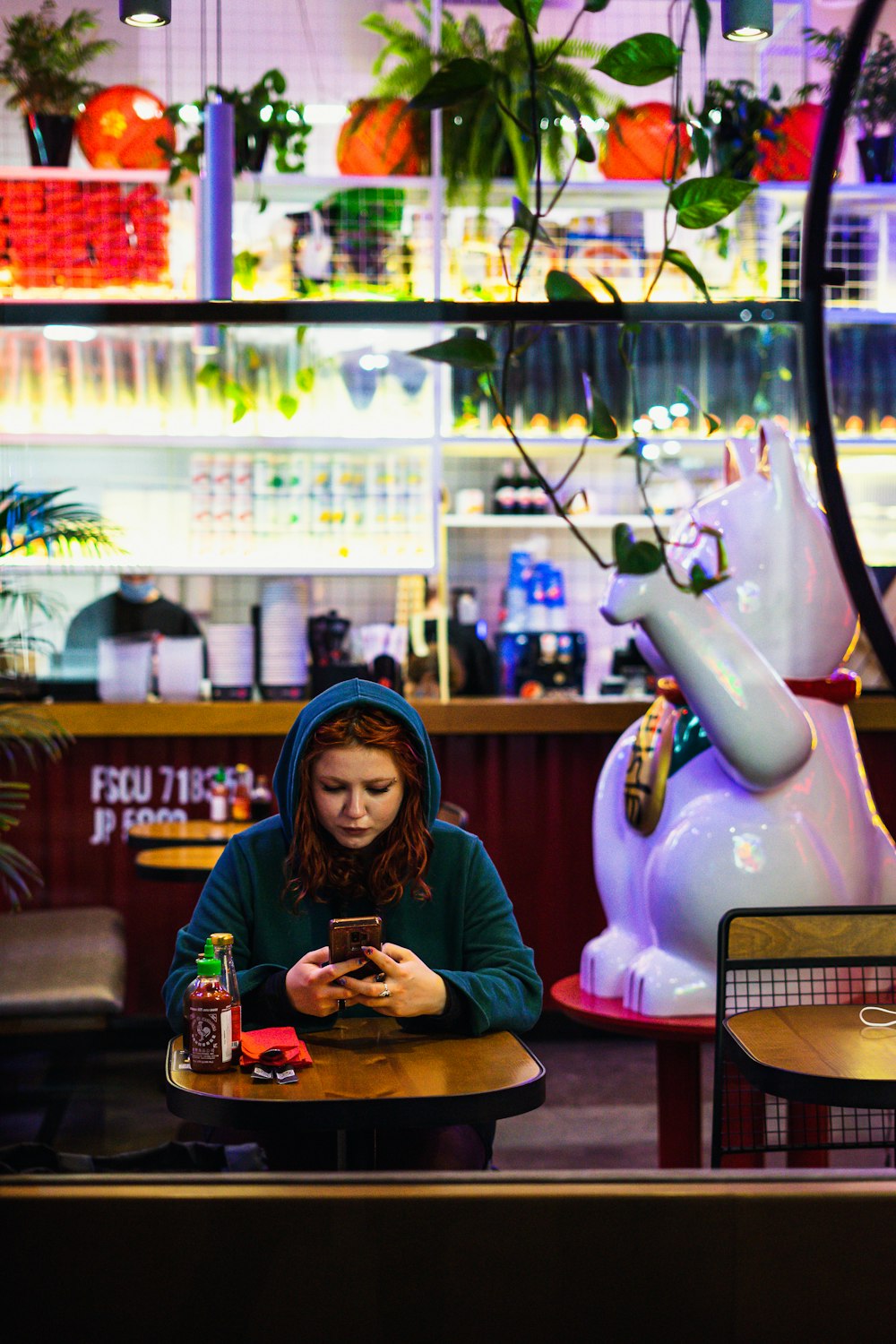 a woman sitting at a table looking at her cell phone