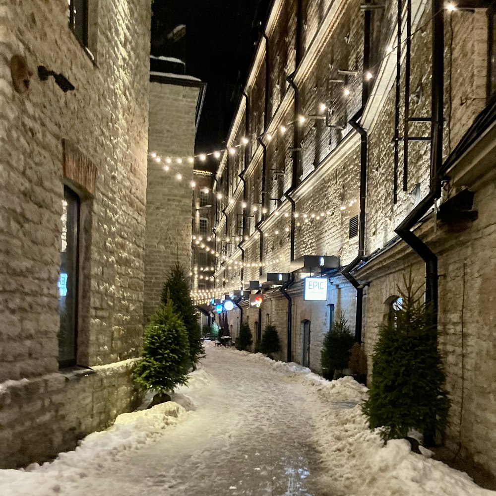 Una calle nevada bordeada de edificios de ladrillo por la noche