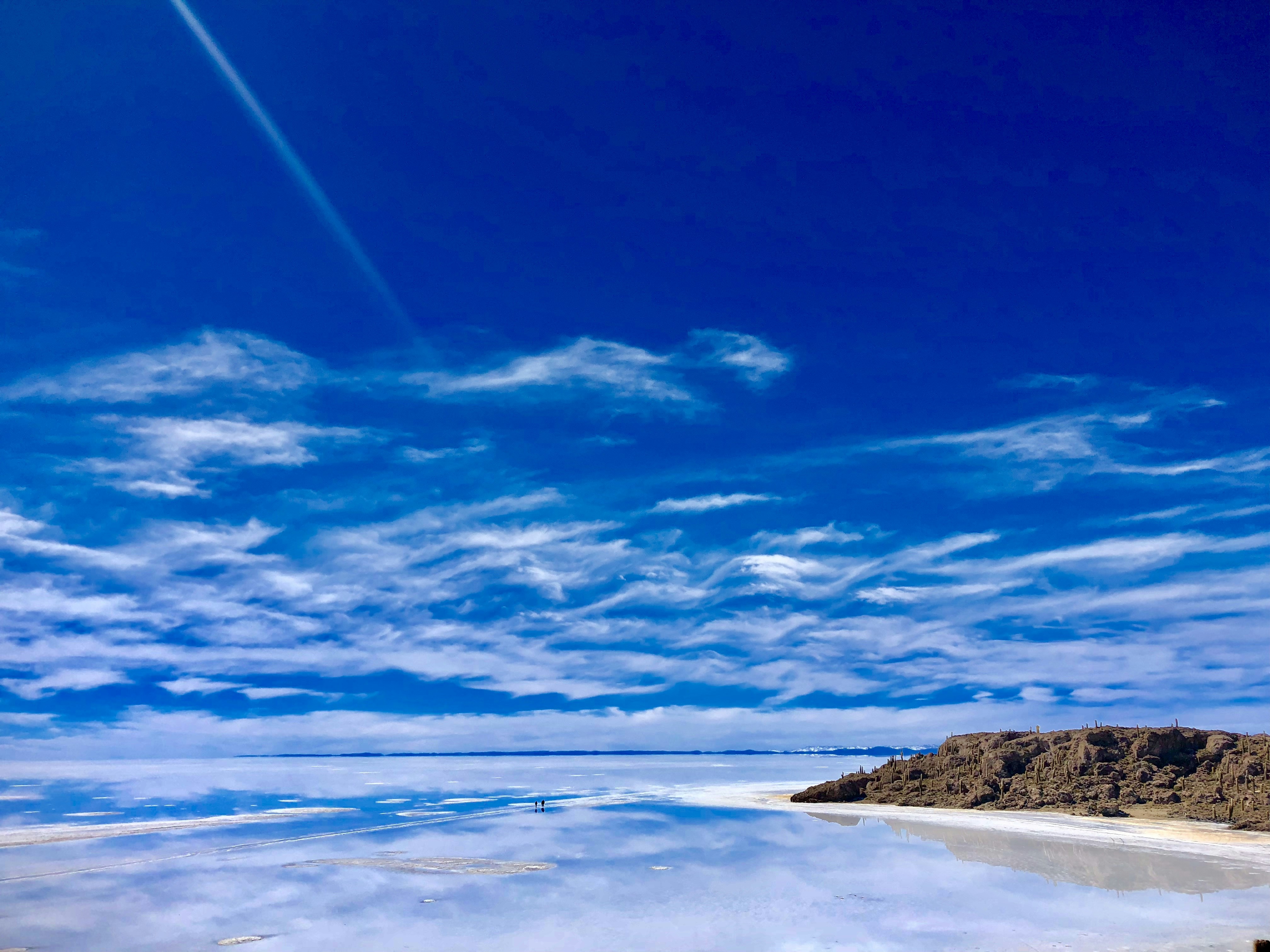 a large body of water sitting under a blue sky