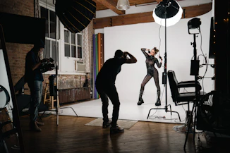 A sleek indoor infinity wall glowing softly under studio lights, with a model posing in front.