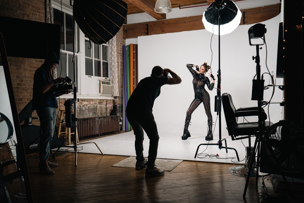 a photographer taking a picture of a woman in a black outfit