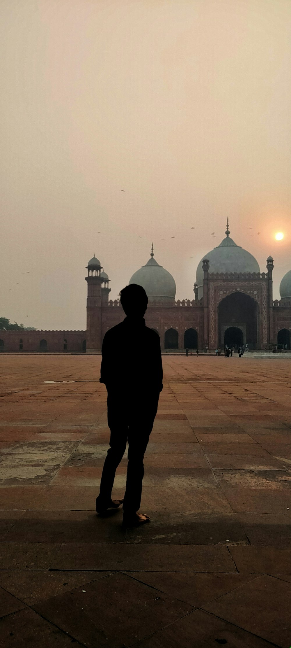 a man standing in front of a large building