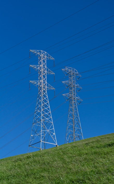a couple of power lines sitting on top of a lush green hillside